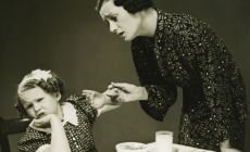 black and white 1930s mother tries to make child eat dinner